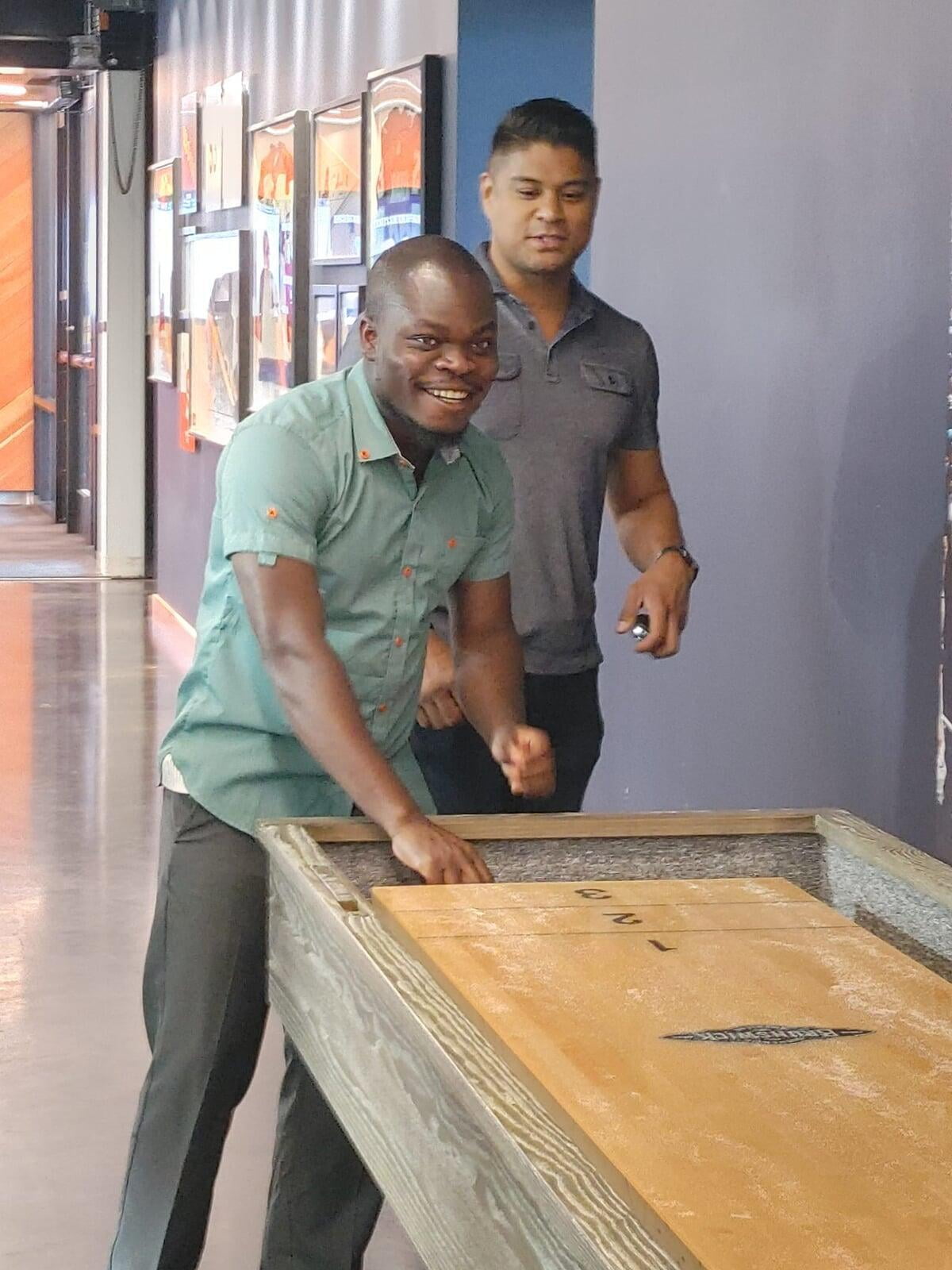 Sean Puno and Olivier Matendo playing a table game together.