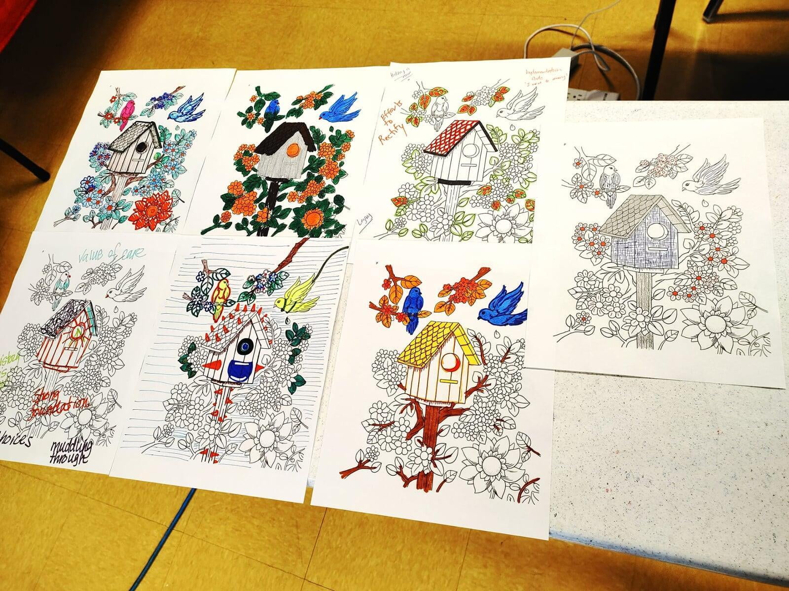 Seven copies of coloring pages colored by Talitha team. The picture on the coloring page consists of a treehouse, flowery shrubs, and two birds.