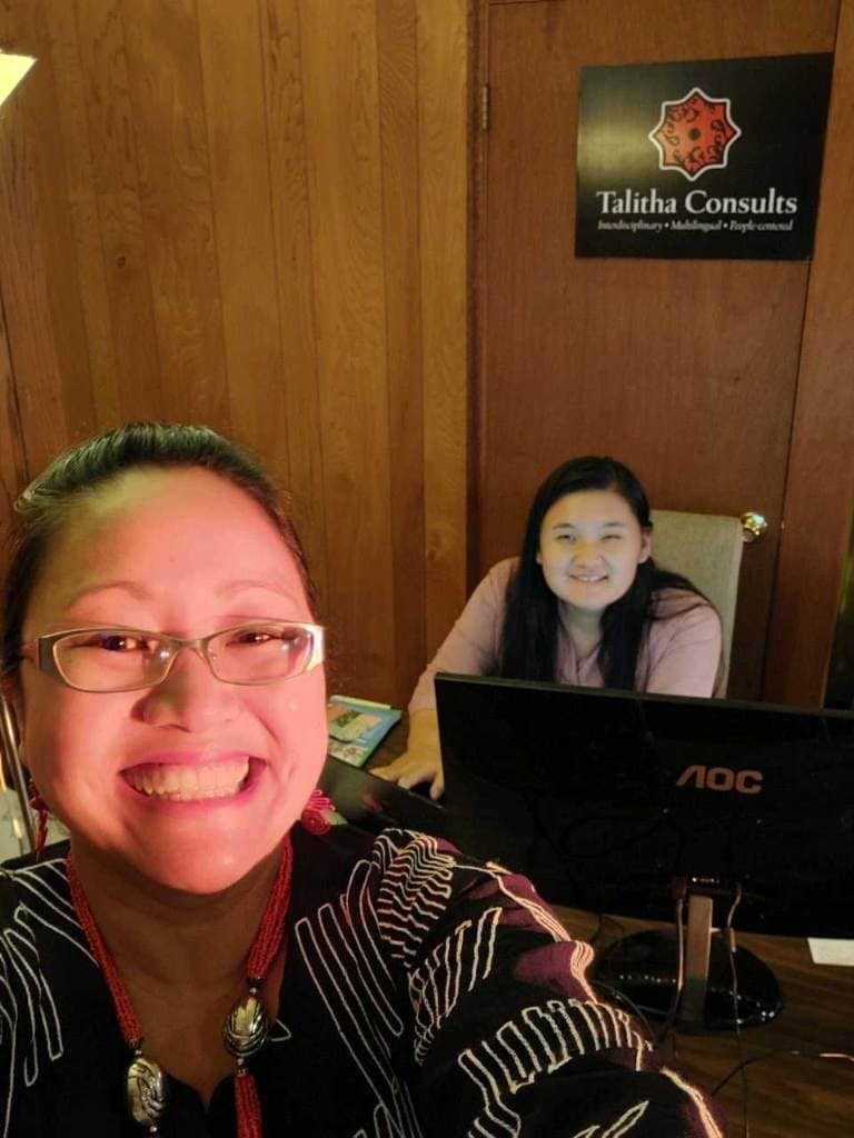 Charis and Ehler smiling while working at a desk